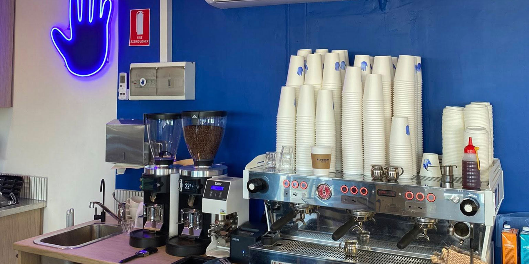 Bluehand’s coffee counter, blue wall and signature hand sign